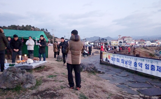 마을주민들이 새해를 맞아 바닷가에서 동신제를 지내고 있다.
