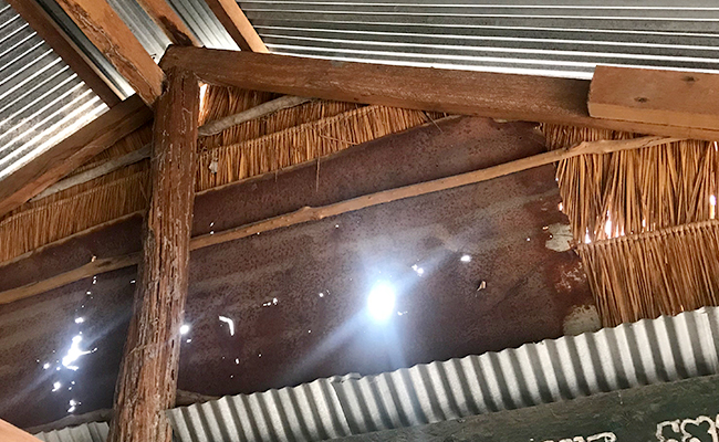 학교의 겉모습 – 제대로 된 문과 창문이 없는 것을 확인할 수 있음. 비가 오면 바람과 빗방울이 모두 교실 내부로 들어와 학생들의 교구가 훼손됨 